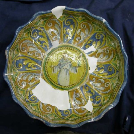 Restauro alzatina in maiolica con girali e clipeo centrale con figura di santo, fase dell'intervento; tipologia di restauro: mimetico antiquariale - Restoration riser in majolica with plant volutes and clypeus with central figure of a saint, step the intervention, type of restoration: invisible